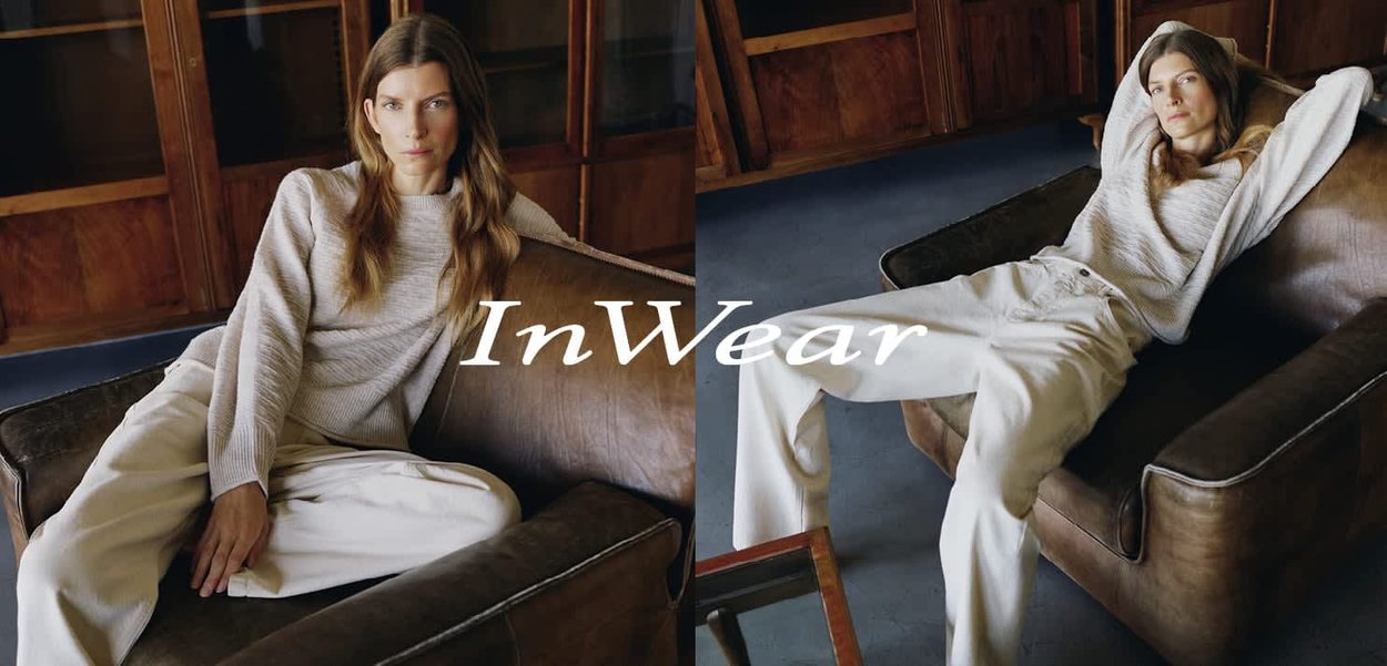 Frau trägt beigen Pullover und weit geschnittene Hose, lehnt sich auf einem braunen Ledersessel in einem Holzraum zurück, mit dem Text "InWear" als Überlagerung.