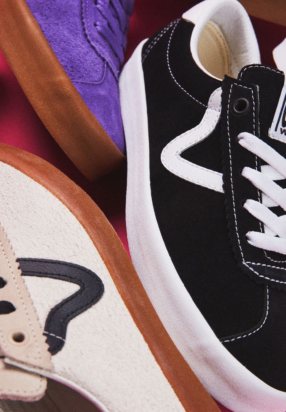 Drei Paar Sneakers: schwarze Wildleder mit weißen Akzenten, lila Wildleder und beiges Wildleder mit schwarzen Details, alle mit Gummisohlen.