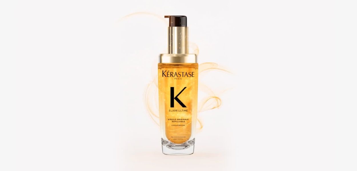 Kérastase Elixir Ultime, une bouteille transparente avec des accents dorés, contenant une huile dorée. Dotée d’un nez-pompe et d’un logo bien visible.
