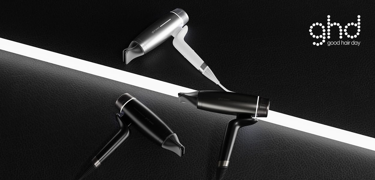 To sorte og en hvid hårtørrer arrangeret på en sort overflade med en hvid diagonal lysstribe og "ghd"-logo.