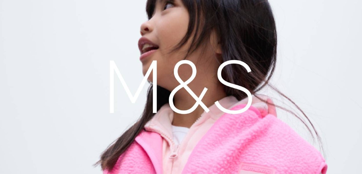 Veste en polaire rose avec une texture douce, dotée d'un col montant et d'une fermeture éclair à l'avant. Portée sur une chemise claire, présentée sur un fond neutre.