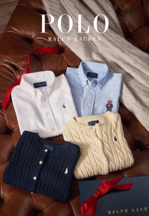 Magliette e maglioni Polo Ralph Lauren piegati in bianco, azzurro chiaro, blu marino e beige su una superficie in pelle con una sciarpa crema e una scatola regalo.
