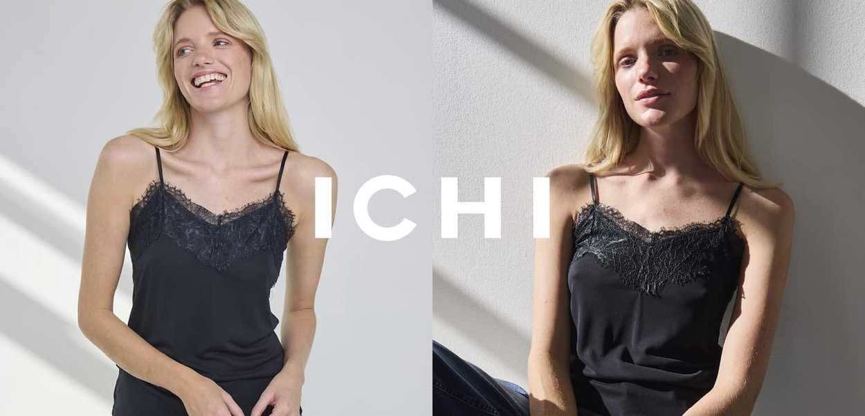 Schwarzes Camisole mit Spitzenbesatz am Ausschnitt, ausgestattet mit dünnen Spaghettiträgern und einer glatten Textur. Das Modell posiert vor einem neutralen Hintergrund.