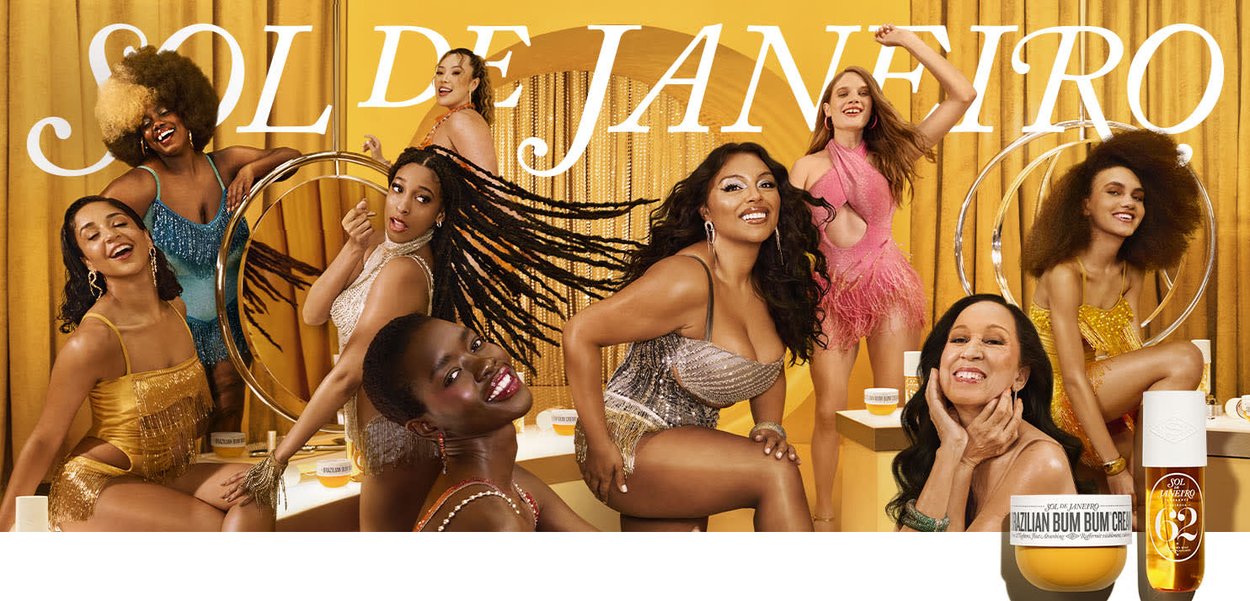 Een diverse groep vrouwen poseert voor een gouden achtergrond, gekleed in levendige, getextureerde outfits. Een Braziliaanse Bum Bum-crème wordt opvallend getoond.