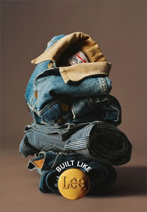 Staplade denim-plagg i olika nyanser av blått, med en kordflossad krage, randiga mönster och en gyllene "Lee"-knapp med text ovanför.