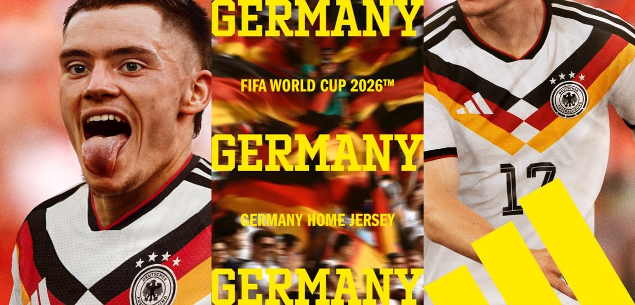 Two soccer players wearing Germany's 2026 FIFA World Cup home jerseys with black, red, and yellow diagonal stripes and fans waving German flags.
