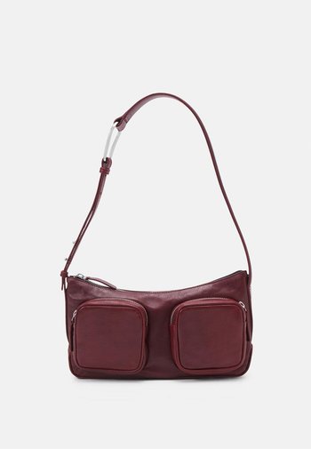 Donker bordeauxleren schoudertas met twee voorzakken, zilverkleurige hardware en een enkele verstelbare schouderriem, met een gladde textuur.