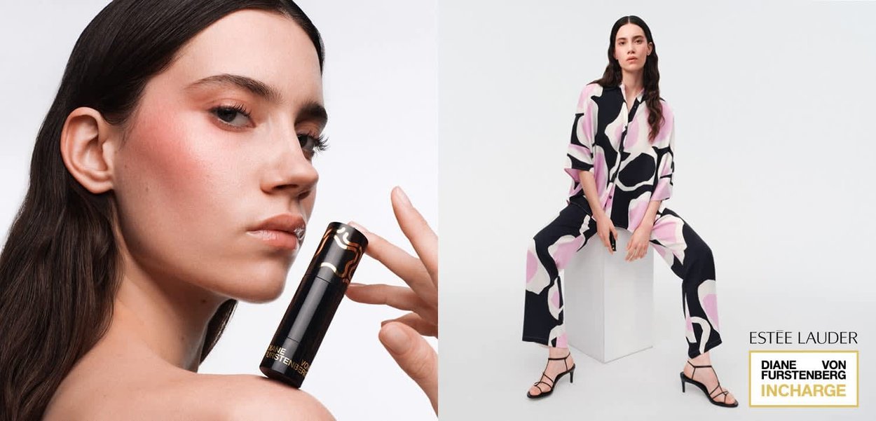 Donna con capelli lunghi e scuri tiene un rossetto Estee Lauder vicino alla spalla; un'altra è seduta su un blocco bianco indossando un outfit con motivo rosa e nero e tacchi.