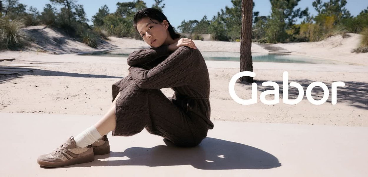 Brown cable-knit outfit with a belted waist, paired with textured brown shoes and white socks. Outdoor setting with trees and a pool.