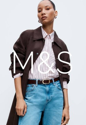 Brązowy płaszcz przeciwdeszczowy noszony na jasnej, w paski koszuli, włożonej do jasnobłękitnych dżinsów z brązowym paskiem. Minimalistyczny design z prostą biżuterią.