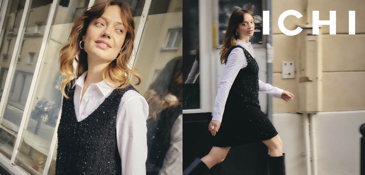 Robe noire sans manches avec une finition texturée et scintillante, associée à une chemise blanche à col. Le modèle a les cheveux lâches et ondulés et porte des bottes hautes noires.