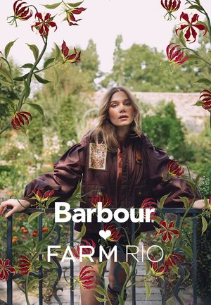 Woman in a garden wearing a brown Barbour jacket, leaning on a black metal gate, surrounded by red and yellow floral illustrations.