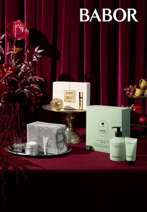 Set BABOR huidverzorgingsproducten, met een doos met gouden accenten, een groene doos met pompje, een zilverkleurig gaastasje en diverse glazen flesjes op een tray.