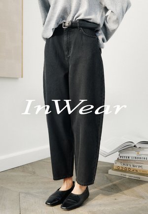 Pantalon en denim noir taille haute avec une coupe décontractée et des passants de ceinture, présentant une texture lisse et des jambes droites.