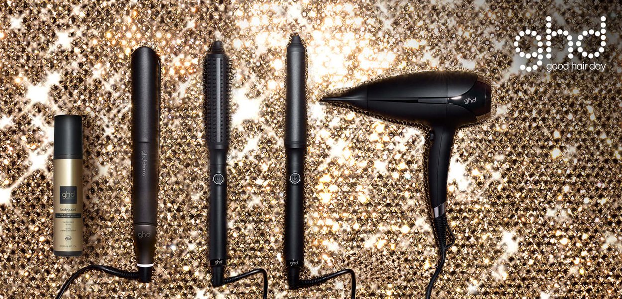 Ensemble d'outils de coiffure noirs sur un fond de sequins dorés, comprenant un spray, une baguette, un fer à friser et un sèche-cheveux, avec des designs élégants.