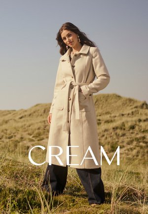 Cremfarbener Wollmantel mit einem taillierten Gürtel, knöpfbarem Vorderteil und großen Taschen. Lange Ärmel und ein klassischer Kragen vervollständigen das Design.