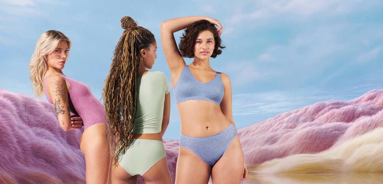 Tre donne posano in lingerie pastello: un body rosa, un top verde menta con slip, e un bralette blu strutturato con slip coordinati.