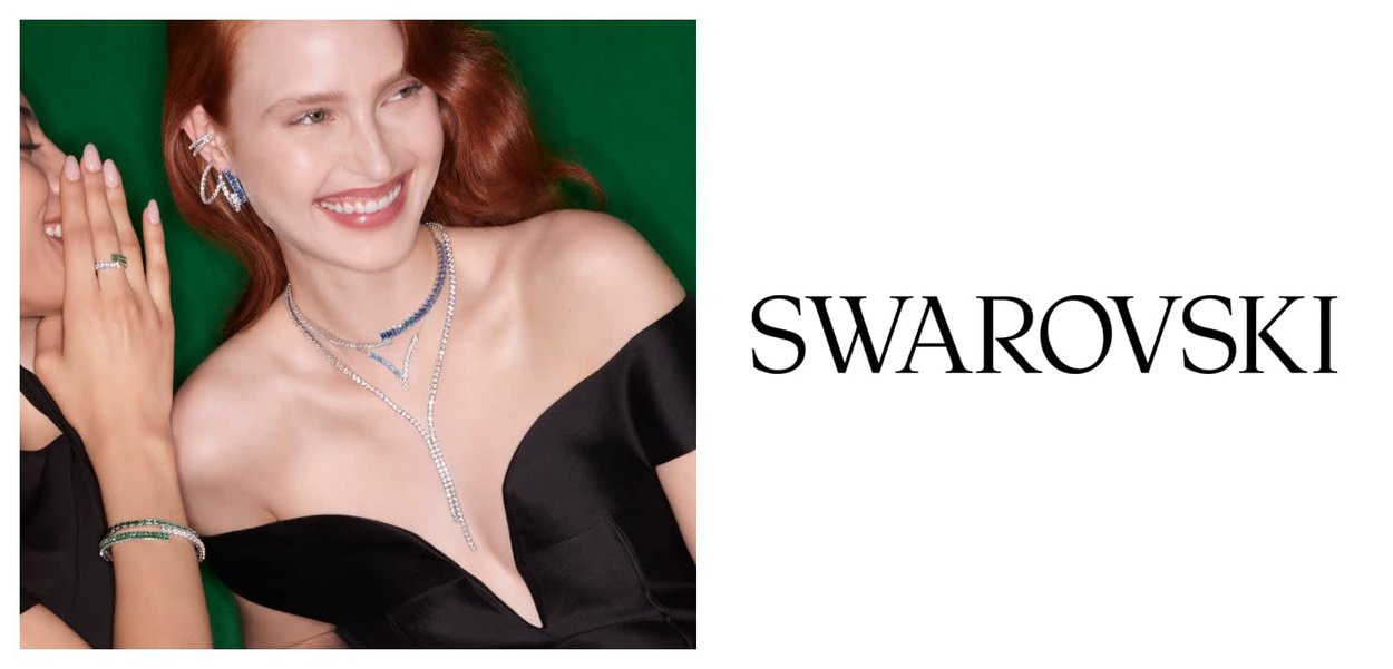 Collier et boucles d'oreilles ornés de cristaux clairs et bleus, assortis à une robe noire épaules dénudées, présentés sur un fond vert.