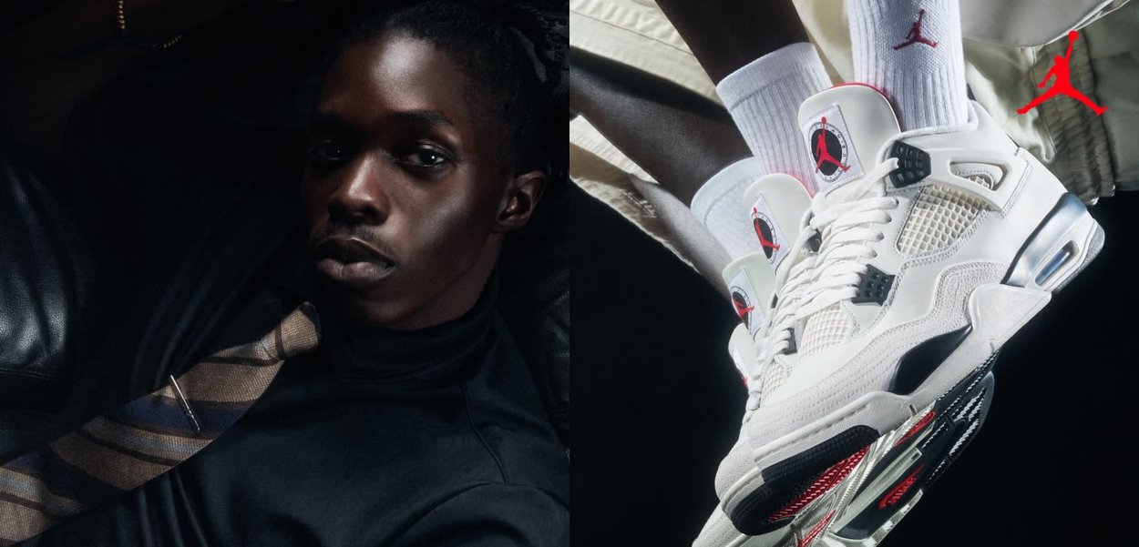 Homme à la peau foncée portant une chemise noire et une cravate rayée, à côté de baskets Air Jordan blanches et rouges assorties à des chaussettes.