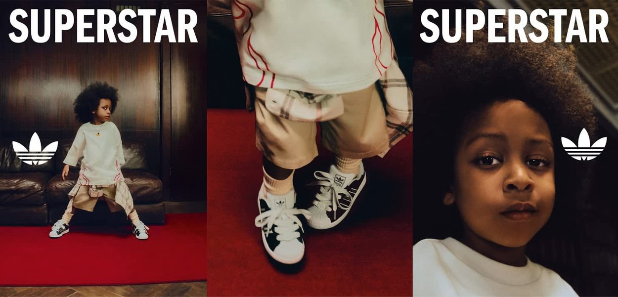 Bambino con capelli afro che indossa scarpe Adidas e abiti casual, in piedi con sicurezza su un tappeto rosso in una stanza elegante.