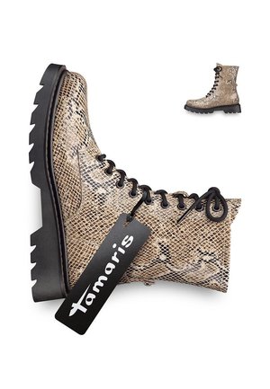 Beige enkelboot met slangenhuidpatroon, zwarte veters, robuuste zwarte zool en een zwart label met "Tamaris."