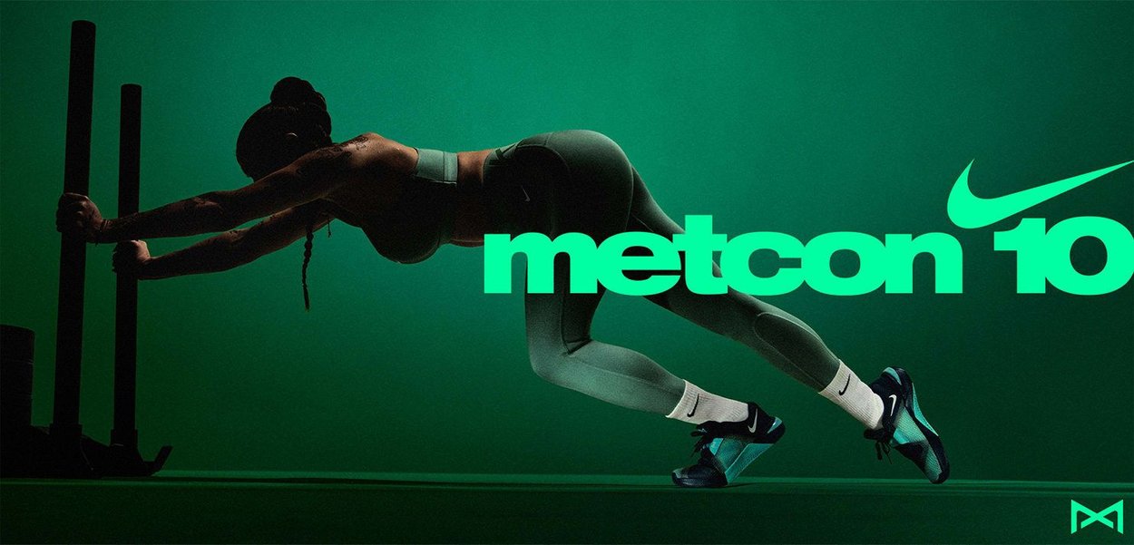 Nike Metcon 10 shoes in teal and black, featuring a sleek design, with textured fabric and prominent branding against a green background.