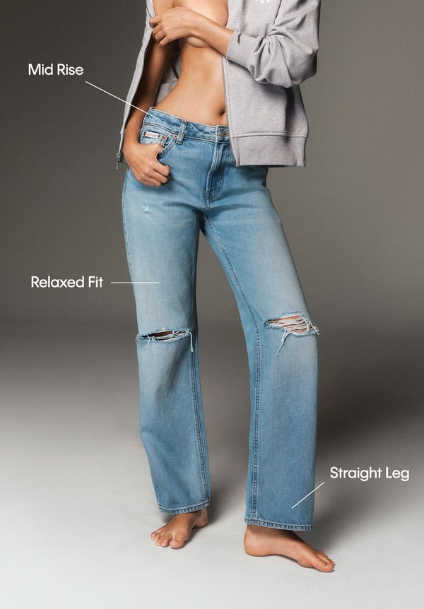 Pantalones vaqueros de corte medio y ajuste relajado en denim azul claro, con detalles rasgados, diseño de pierna recta y un acabado natural.