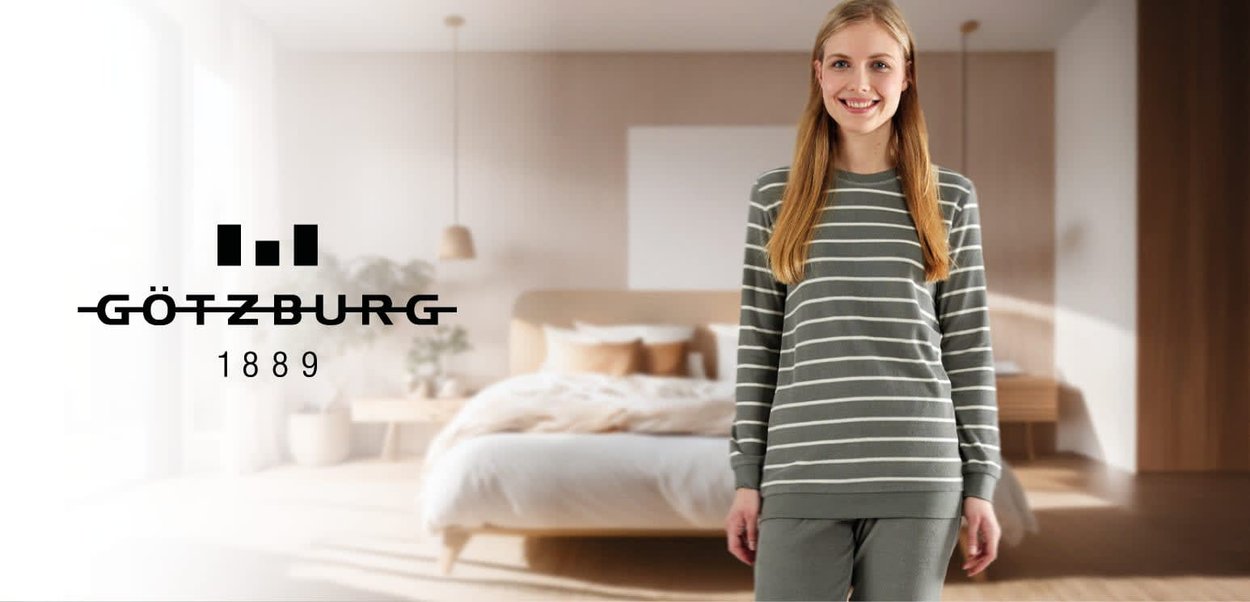 Grijs en wit gestreept loungewear set met een lange mouw top en bijpassende broek, weergegeven in een gezellige, zacht verlichte slaapkameromgeving.