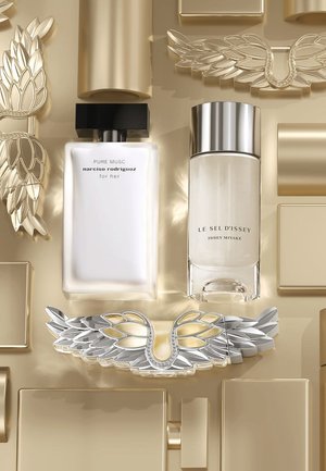 Deux flacons de parfum au design rectangulaire minimaliste, l'un en verre transparent avec des accents argentés, l'autre blanc avec un bouchon noir. Fond décoratif doré.