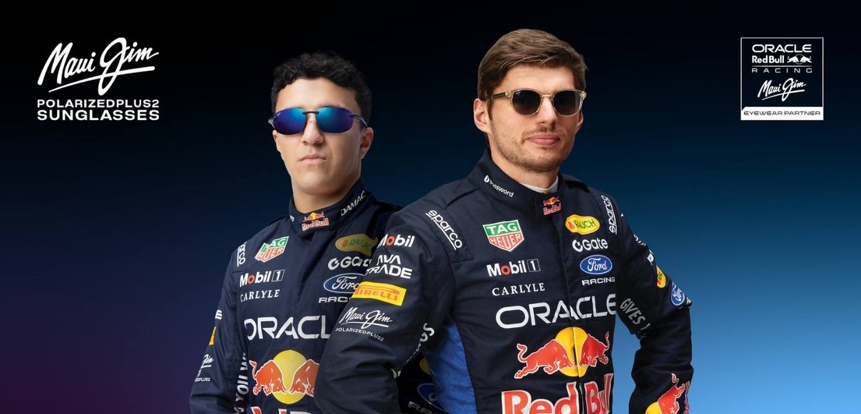 Twee mannen in Oracle Red Bull Racing-overalls met Maui Jim-zonnebrillen staan zelfverzekerd tegen een donkere achtergrond.