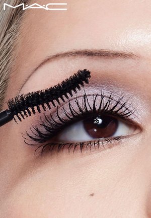 Black mascara is applied to lush, long eyelashes. The eye has neutral eyeshadow, and a smooth skin texture is visible around the eye.