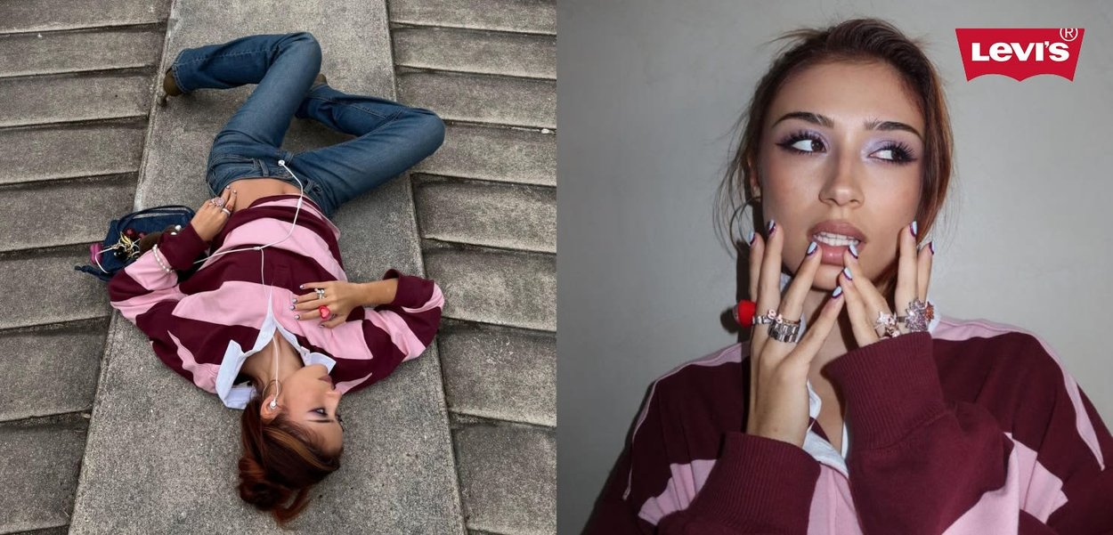 Jeune femme portant un pull à rayures bordeaux et roses, posant allongée sur des marches en béton en touchant son visage, logo Levi’s dans un coin.