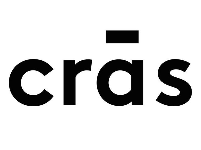 Texte noir en gras épelant "crås," avec une ligne horizontale au-dessus de la lettre 'a.' Le design est minimaliste avec des formes arrondies et géométriques.