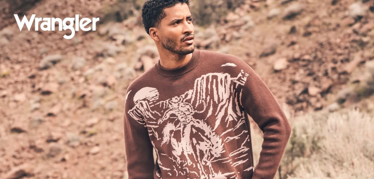 Brun genser med et grafisk design av et røft landskap, med en fremtredende figur til hest i hvite toner. Strikket tekstur, rund hals.