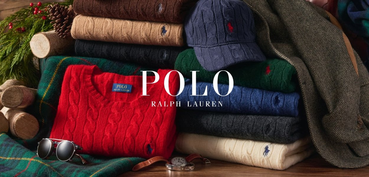 Pull en tricot rouge avec col côtelé, entouré de pulls de différentes couleurs y compris vert, bleu marine, noir et crème. Comprend également une casquette et des lunettes de soleil.