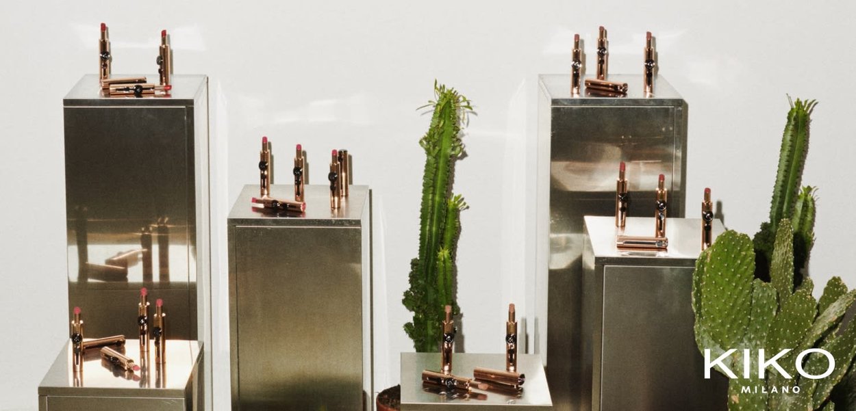 I rossetti KIKO Milano esposti su piedistalli metallici con cactus. I rossetti presentano un rivestimento dorato e nero; le tonalità variano dal rosa al nude.