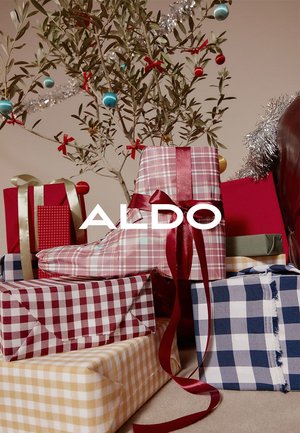 Gaveæsker i forskellige farver og mønstre, herunder rød plaid, gul ternet og blå ternet, med bånd og en olivengren i baggrunden.