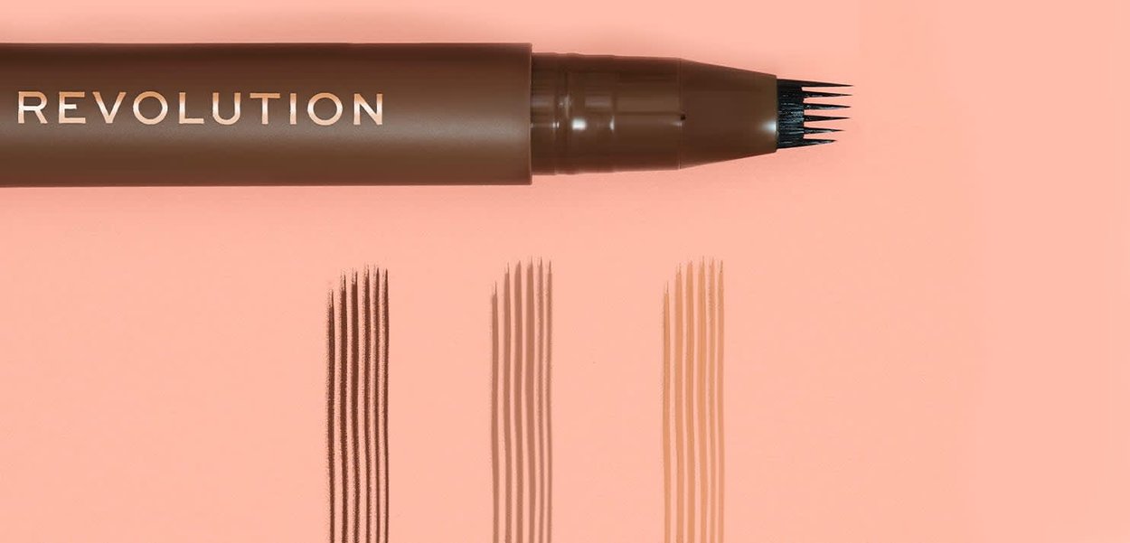 Penna per sopracciglia marrone con una punta a quattro punte che mostra tre serie di sottili tratti paralleli in tonalità marrone scuro, medio e chiaro.