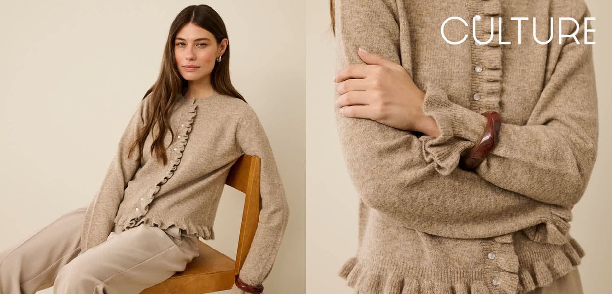 Cardigan tricoté beige en tissu texturé, fermeture à boutons, ourlet et poignets volantés. Modèle assis sur une chaise, portant un pantalon beige.