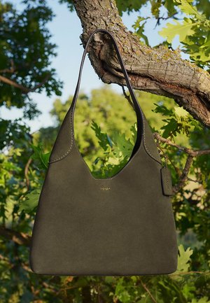 Olivgrüne Lederhandtasche in Hobo-Form, mit glatter Wildlederoberfläche, gebogenem Schulterriemen und geprägtem Logo-Detail.