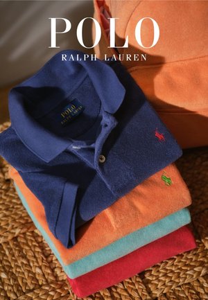 Pila de camisas Polo Ralph Lauren dobladas en azul marino, naranja, verde azulado y rojo con logotipos bordados sobre una superficie tejida y superposición del nombre de la marca.