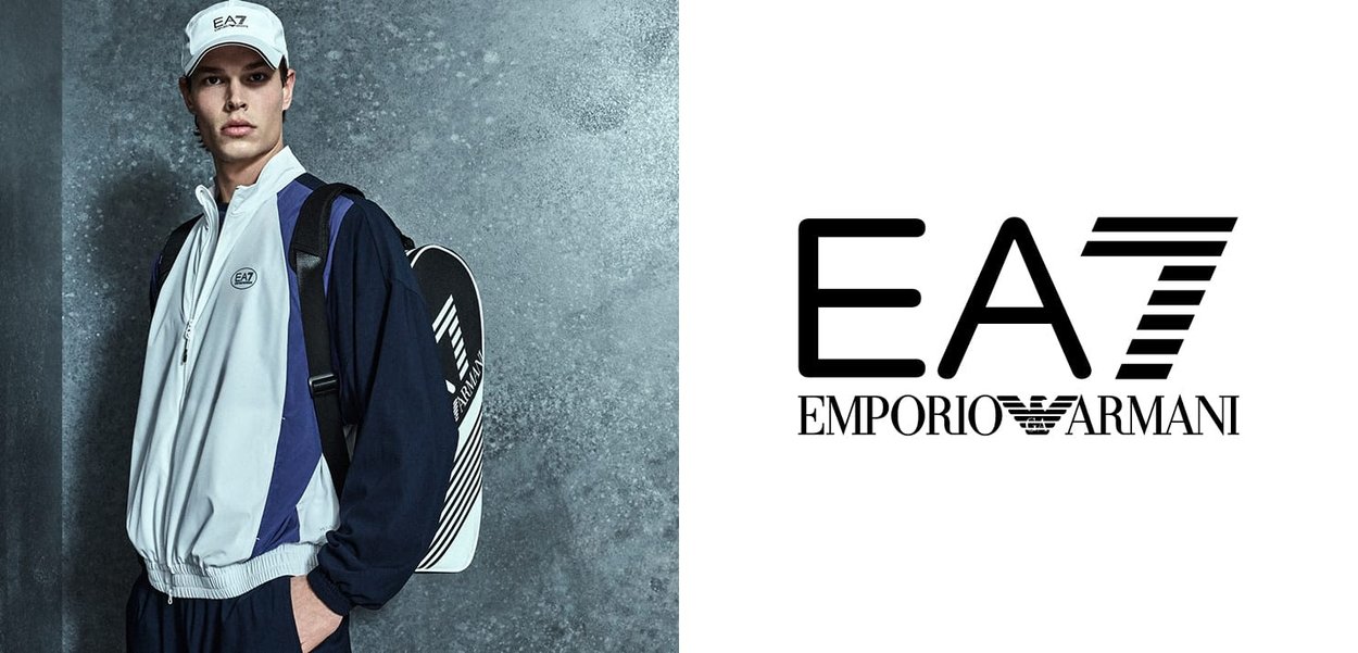 Veste de sport gris clair et marine avec col montant, fermeture éclair et logo EA7 ; assortie d'une casquette. Présente des lignes épurées et un design athlétique.