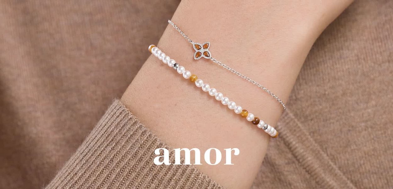 Bracciale in argento con un charm floreale, abbinato a un bracciale di perline multicolori che presenta perle e pietre nei colori rosa, marrone e giallo.