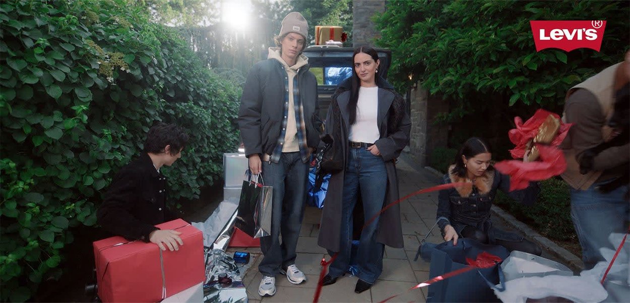 Levi's clothing: a casual pair of jeans, a black puffer jacket, a white top, and accessories; various gift-wrapped items on the ground.