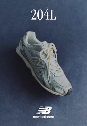 Sneaker bianco New Balance realizzato in materiali mesh e sintetici, design con lacci, collo imbottito e un accento del logo argentato. Modello 204L.