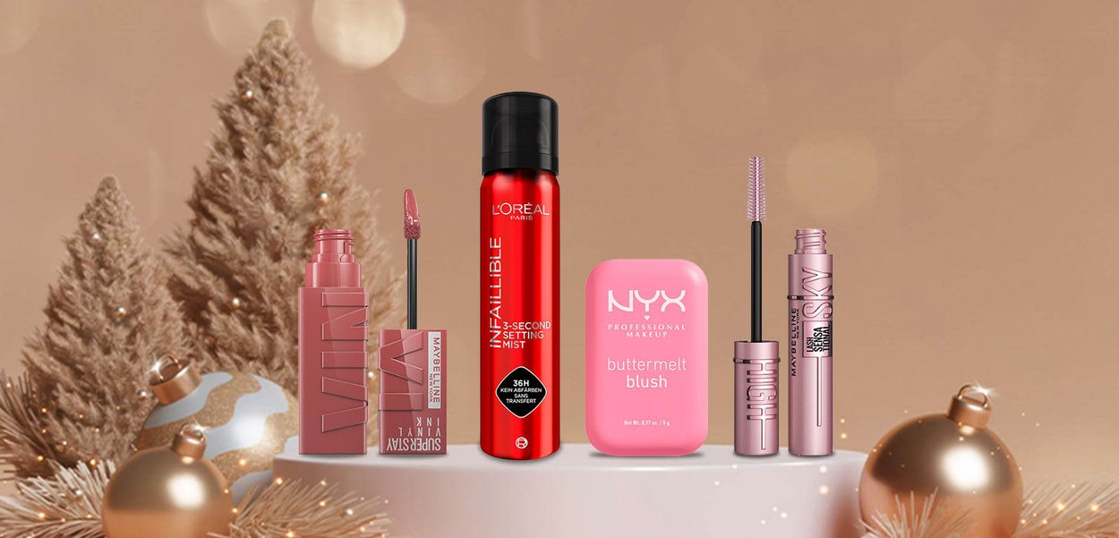 Collection of cosmetics including matte liquid lipstick, setting mist, cream blush, and mascara, featuring various sleek packaging in pink and red tones.