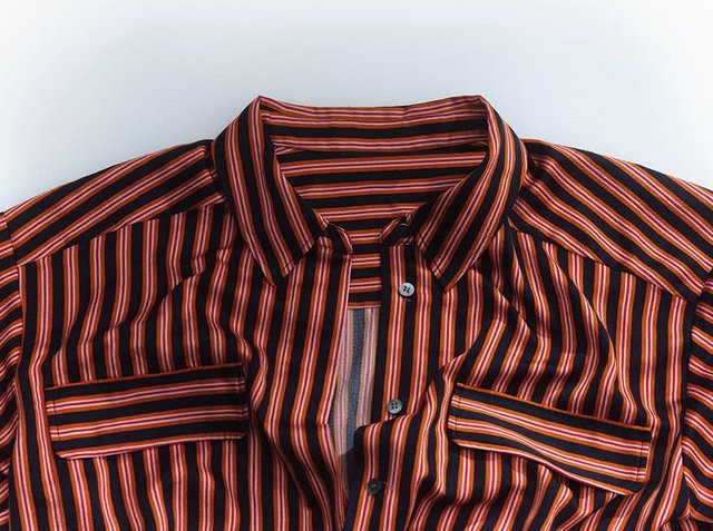 A striped button-up shirt in red, orange, and black. It features a collar, two front pockets, and vertical stripes of varying widths.