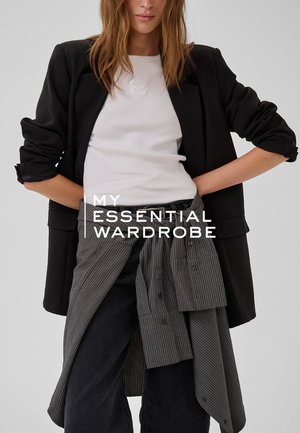 Schwarzer Blazer mit hochgekrempelten Ärmeln, weißes, geripptes T-Shirt und grauer Wickelrock mit Nadelstreifen über dunklen Jeans. Textüberlagerung: "MEINE UNVERZICHTBARE GARDEROBE."