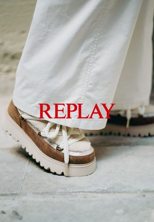 Bruna mocka plattformssneakers med vita snören och ett strukturerat tygöverdel, med en tjock vit sula och subtil branding.