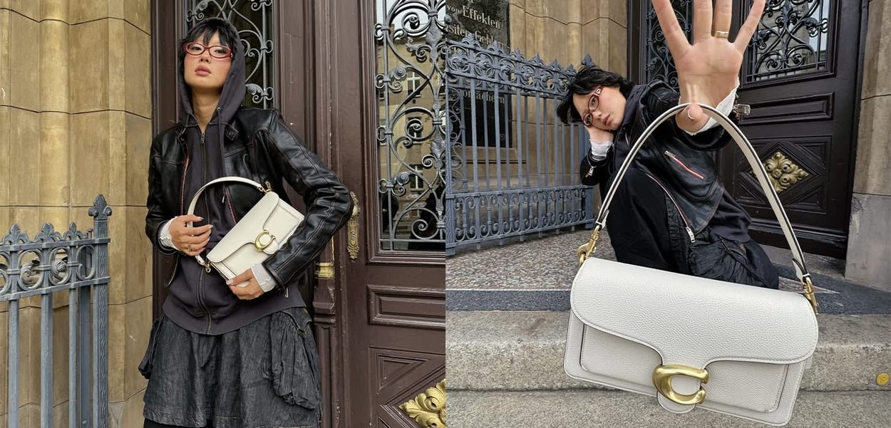 Weiße Lederhandtasche mit einer geschwungenen Klappe und goldenen Hardware-Details. Das Design verfügt über einen runden Griff und eine strukturierte Oberfläche.